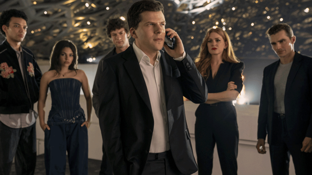 Homem falando no celular com um grupo de pessoas atrás.