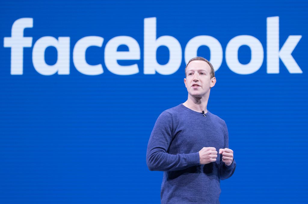 Mark Zuckerberg discursa em frente a um telão com o logo do Facebook