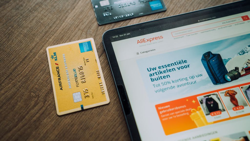 Cartão de crédito ao lado da tela de um tablet aberta no sie do AliExpress