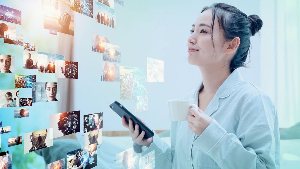 Imagem mostra jovem asiática assistindo a vídeos com um smartphone