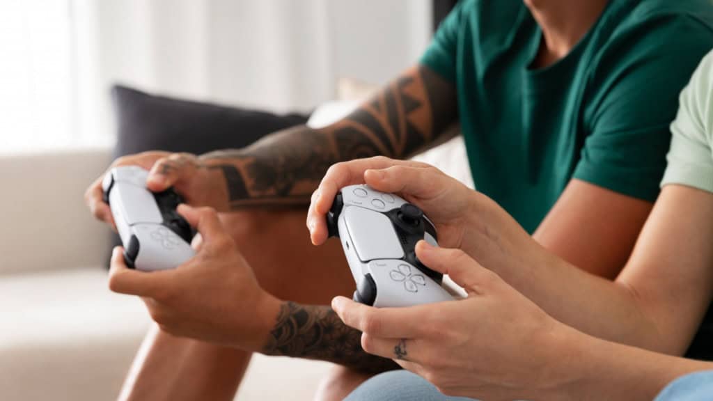 duas pessoas jogando videogame com controles do Playstation 5