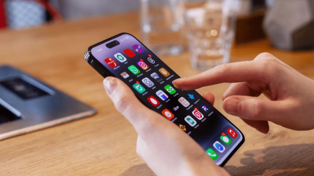 Pessoa utilizando um celular com vários aplicativos